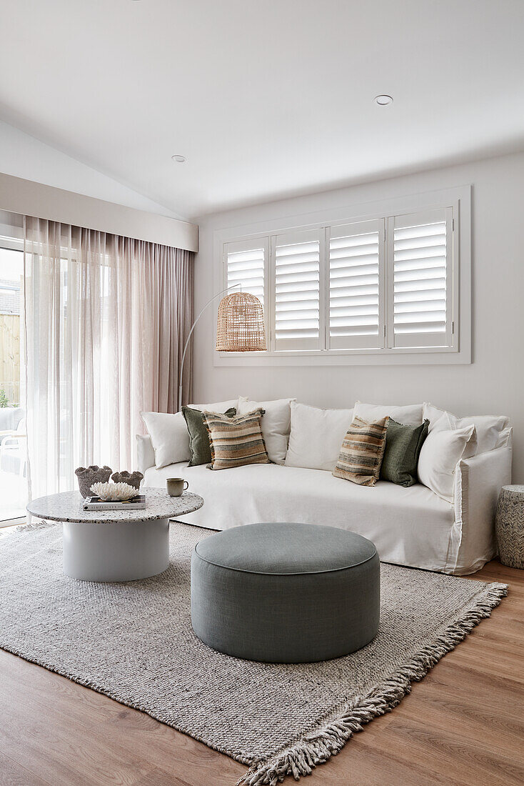 Modernes Loungezimmer im Scandi-Stil mit weißem Leinensofa, Plantagenfensterläden, Terrazzo-Couchtisch und Eichenboden