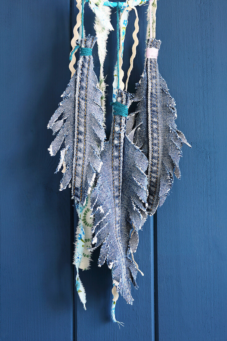 A dream catcher featuring feathers made from leftover denim