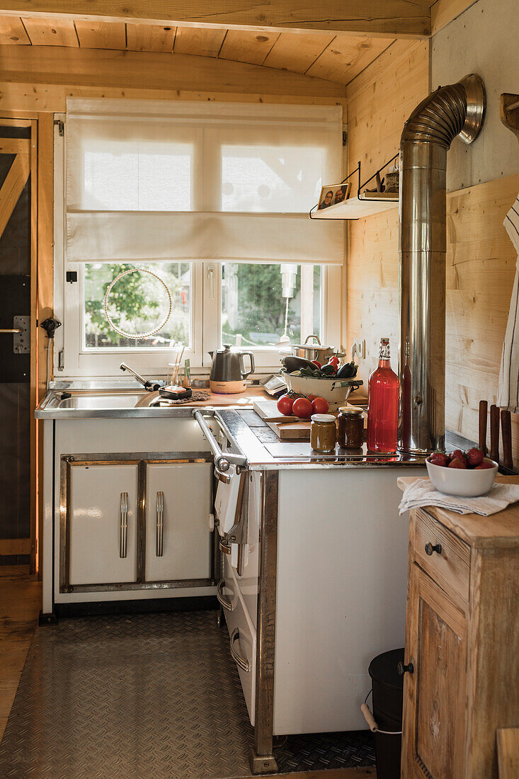 Kleine Küche mit Holzofen in ausgebautem Wohnwagen