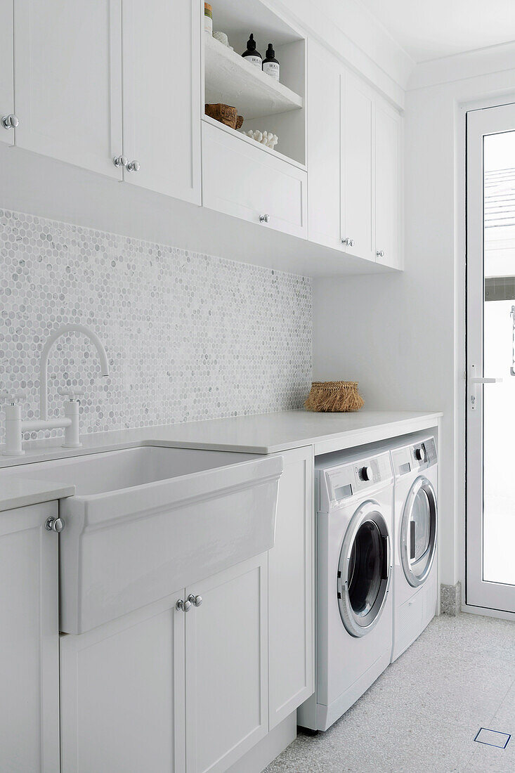 Laundry room with white fixtures and mosaic wall tiles