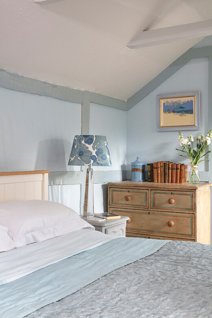 Doppelbett und Kommode im Schlafzimmer in Hellblau und Weiß