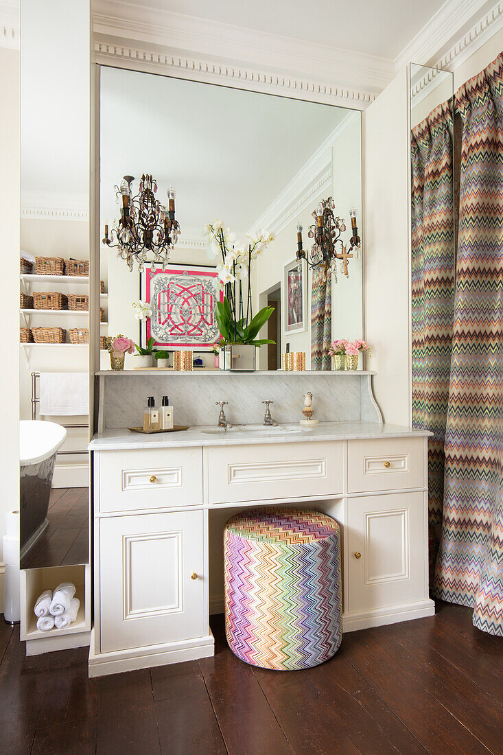 bathroom vanity with sitting pouf, above mirror in a bathroom