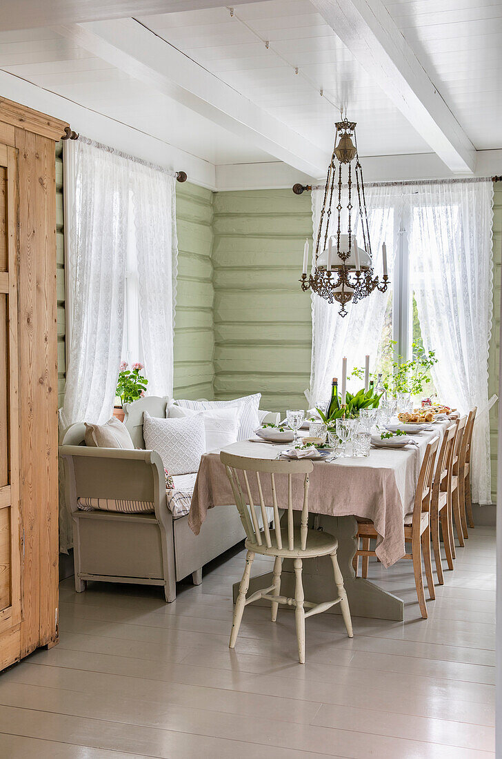 Festive table setting in a cottage with green painted wood paneling
