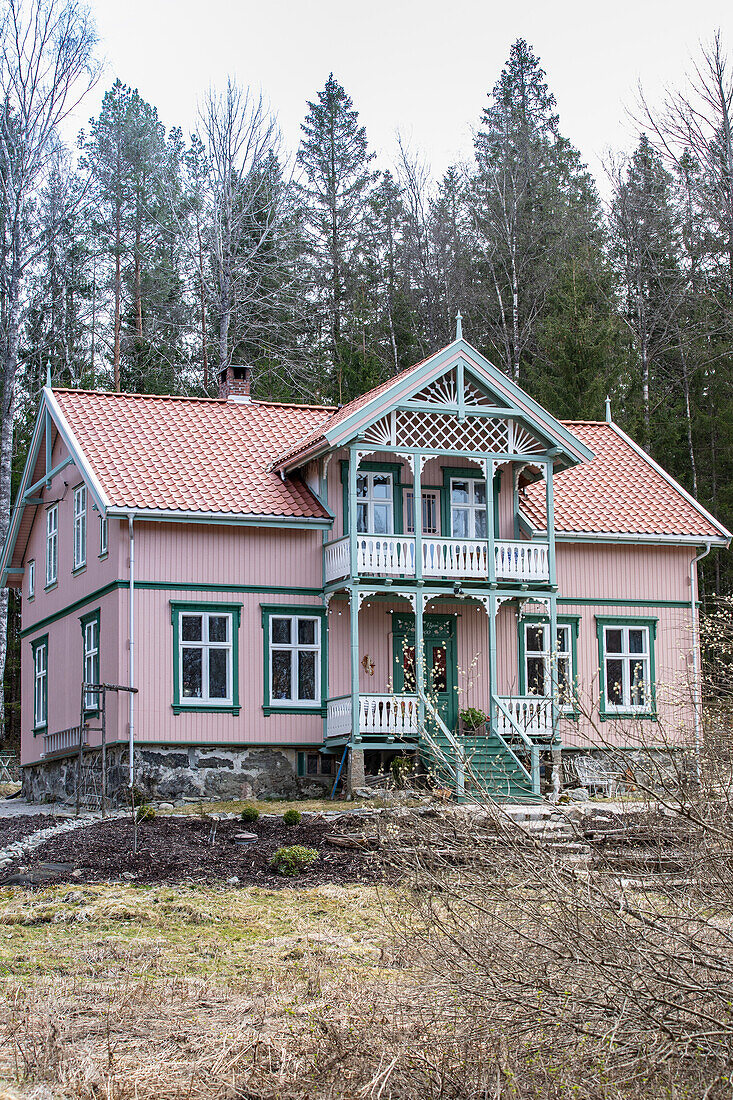 Pink painted wooden house with balcony