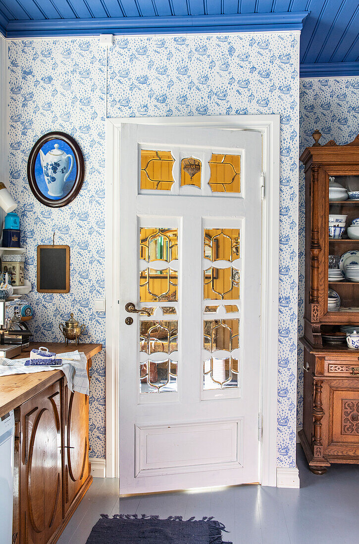 Kitchen with blue and white wallpaper, door with glass windows