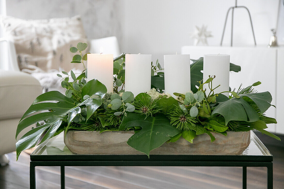 DIY-Adventskranz aus Blättern, mit weißen Stumpenkerzen