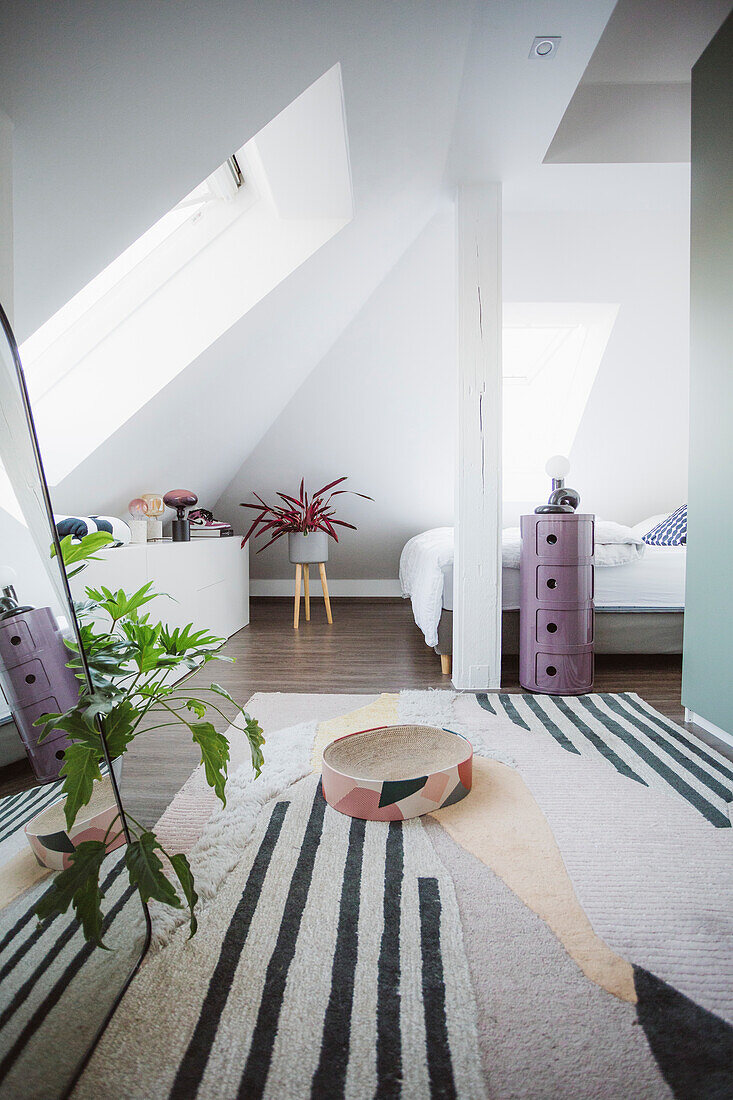 Graphic rug and purple cabinet in an attic bedroom