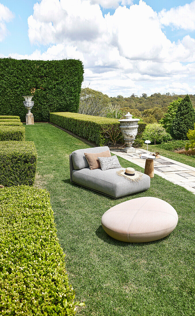 Comfortable armchair in the garden with trimmed hedges