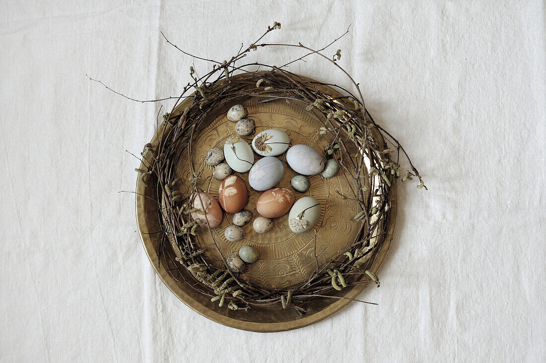 Wreath of willow branches and naturally dyed Easter eggs on vintage tray
