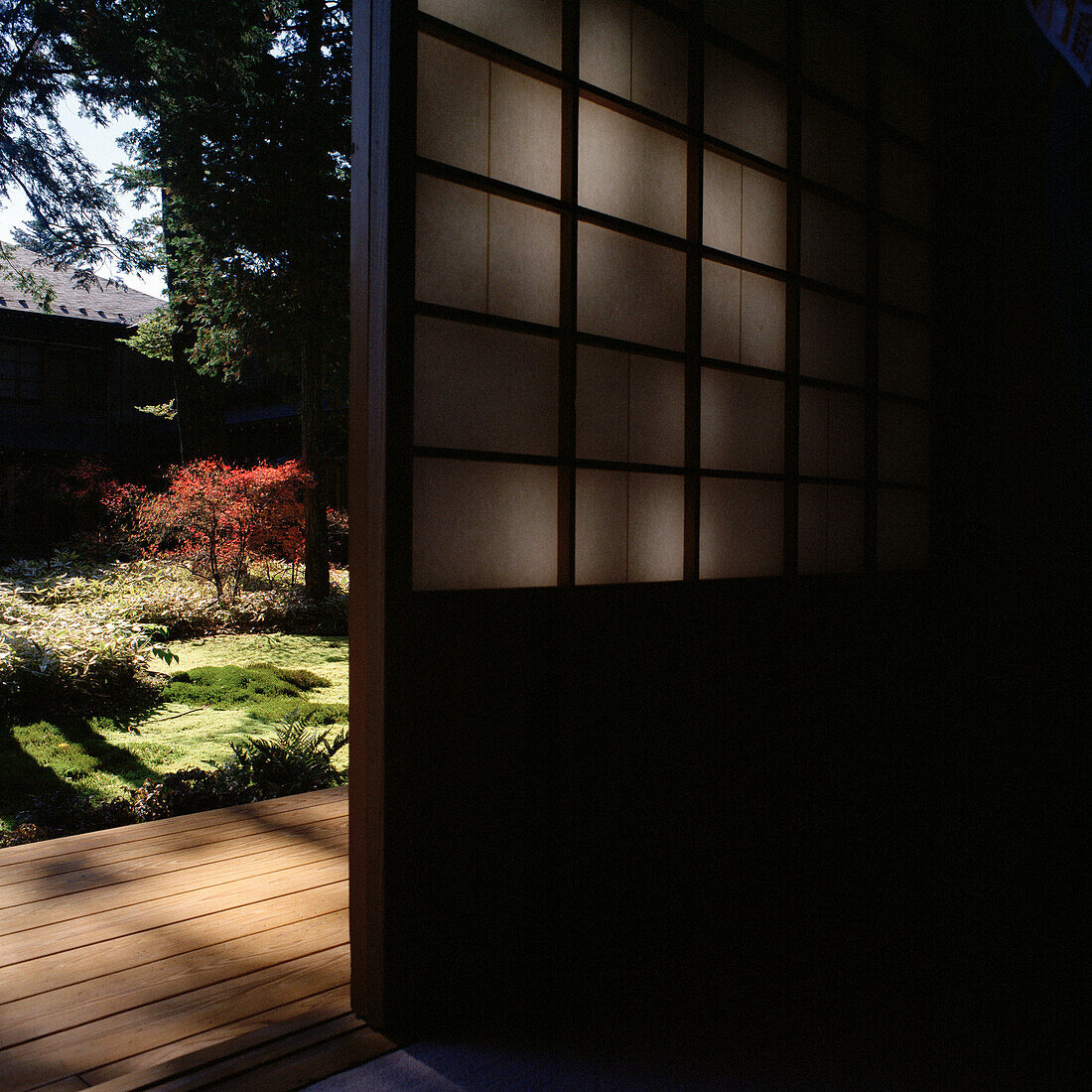 Japanisches Haus mit Blick auf Holzterrasse und Garten