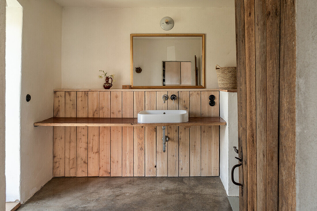 Puristisches Bad mit Holzbrett als Waschtisch und Estrichboden