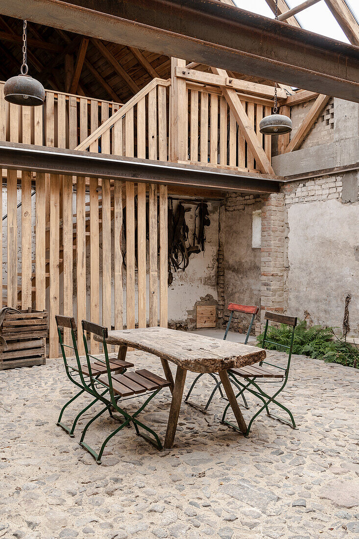 Rustikaler Tisch und Stühle im Innenhof mit Steinboden