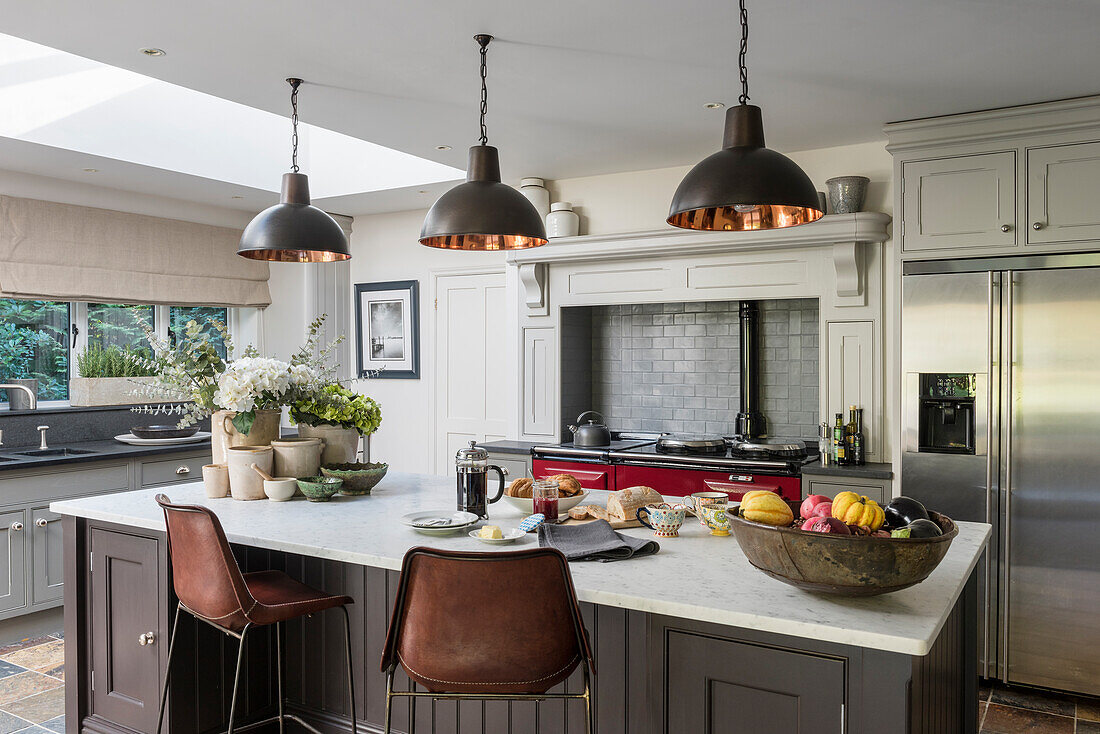 Custom made kitchen island, industrial style pendant lights above in open plan kitchen