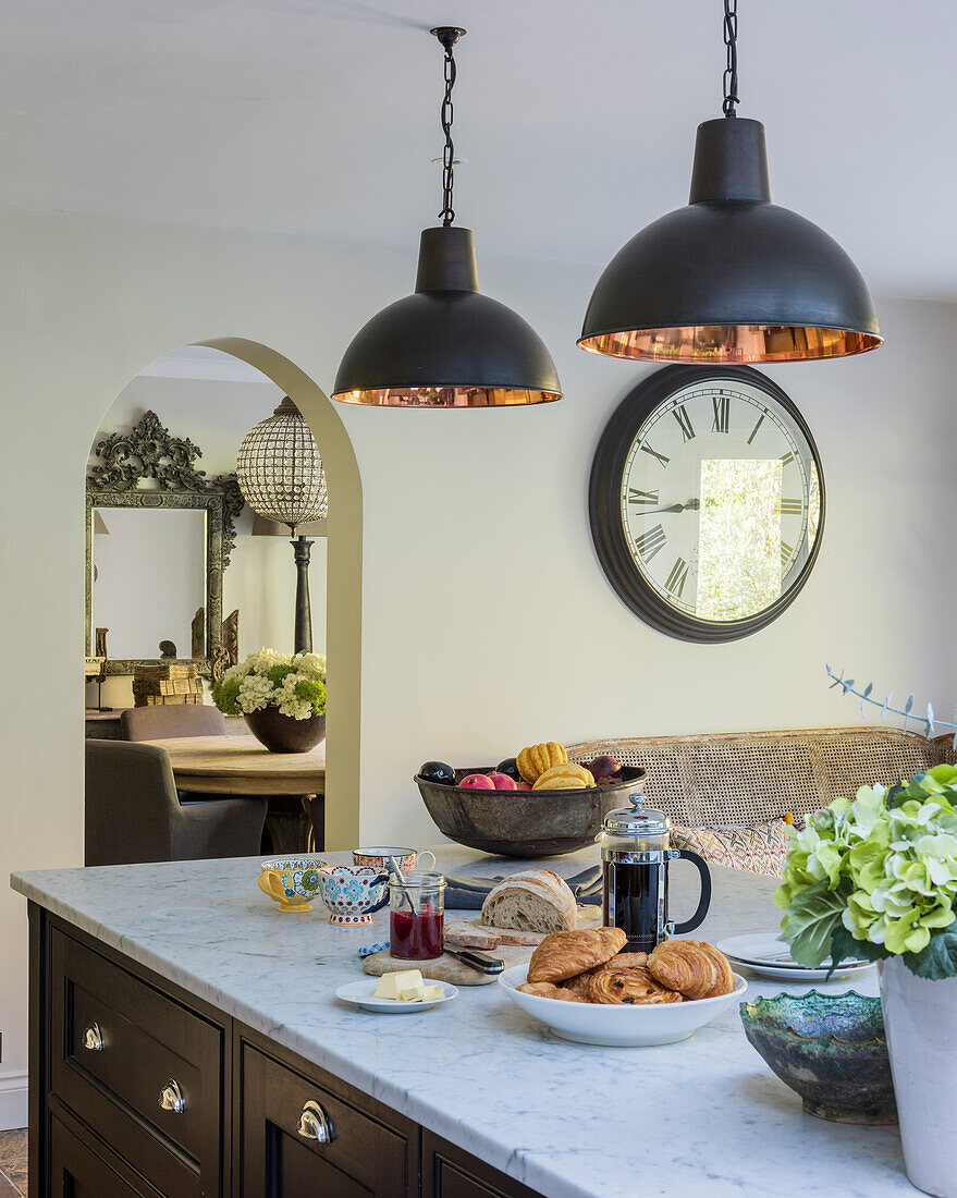 Breakfast served on a custom-made kitchen island with marble top, above industrial style pendant lights