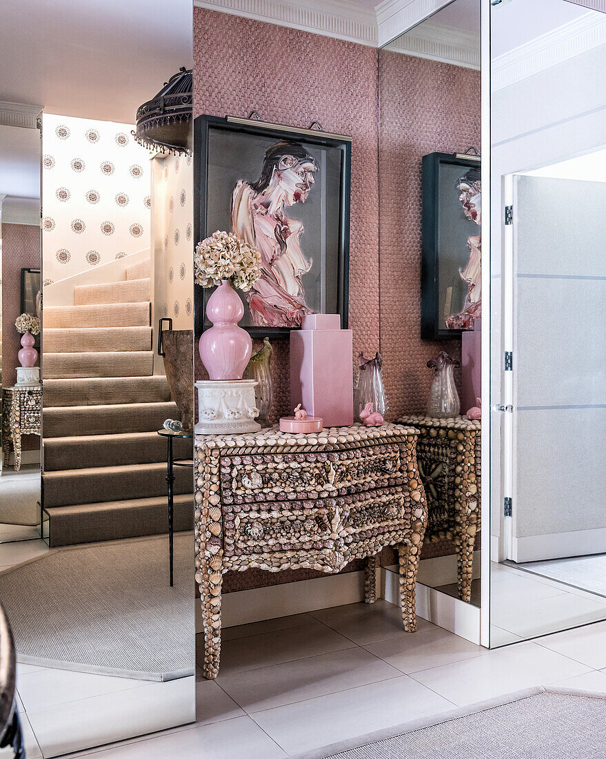 Entrance way with French shell covered antique chest of drawers, artwork above