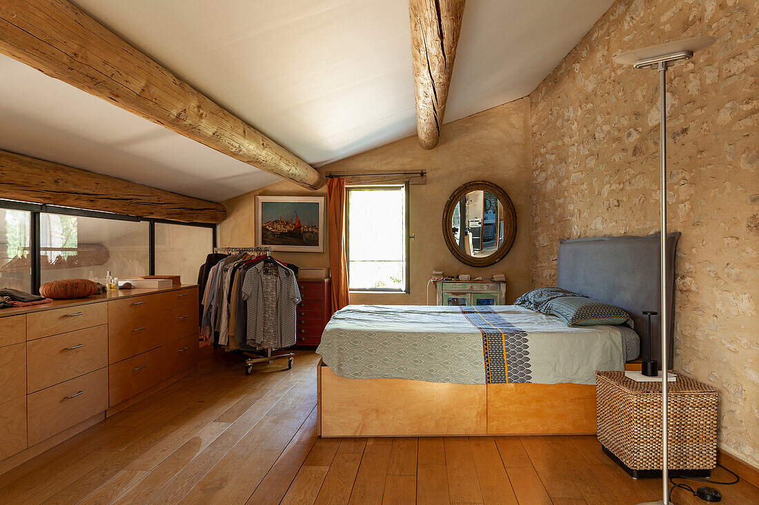Schlafbereich mit Garderobe in einem Landhaus mit Natursteinwand