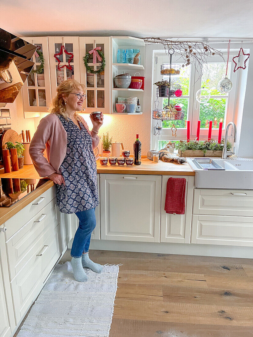 Woman with mulled wine in a farmhouse style kitchen