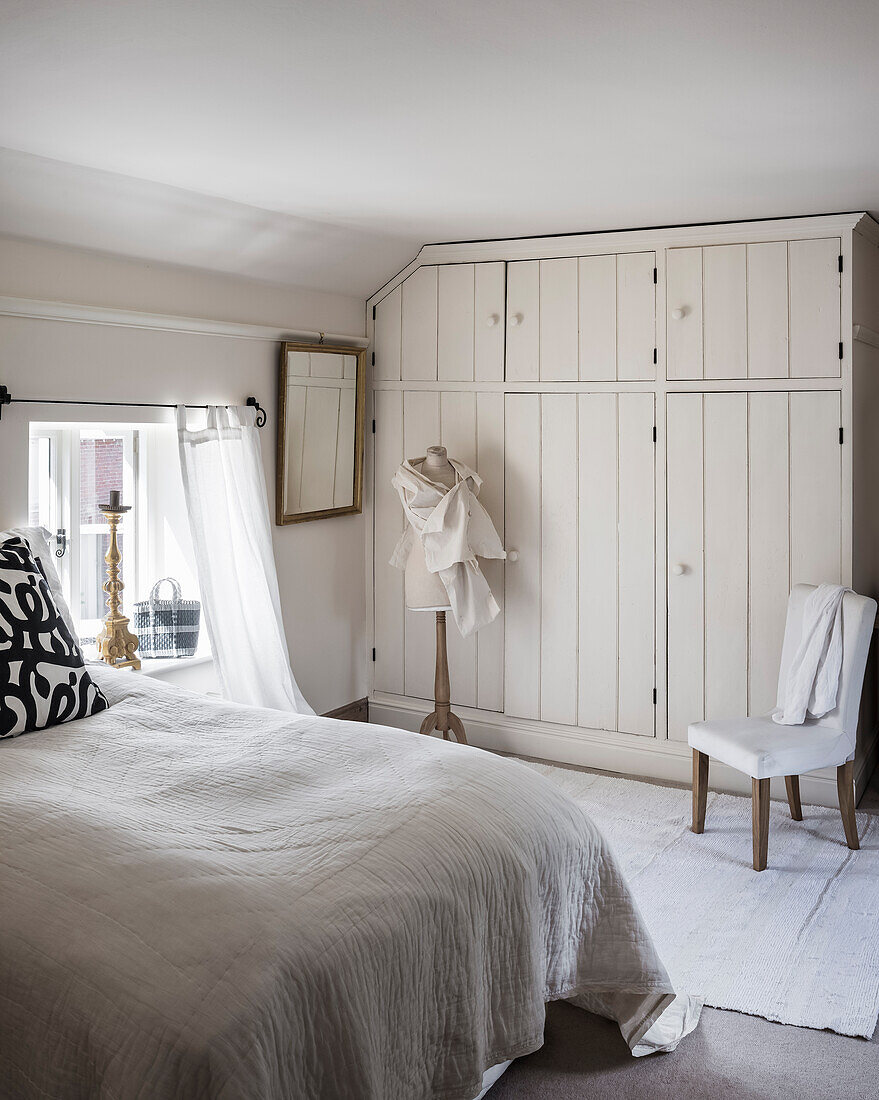 Built-in closets of repurposed floorboards in a light, airy bedroom