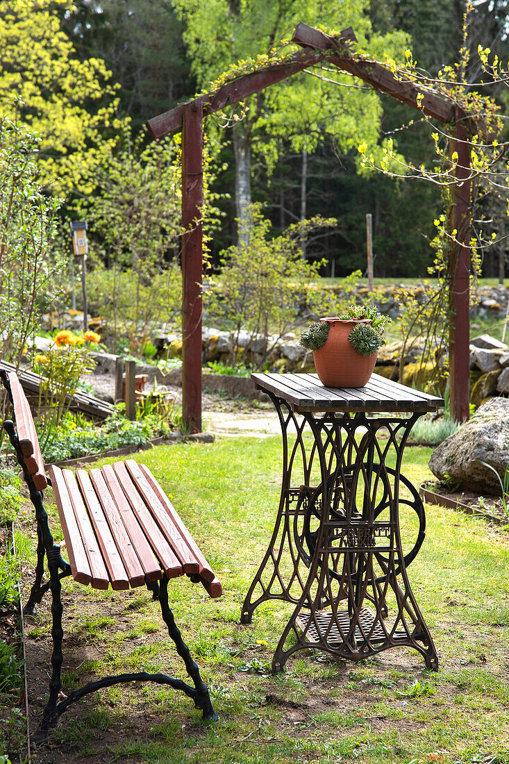 Einladender Sitzplatz mit Tisch aus alter Nähmaschine im Garten