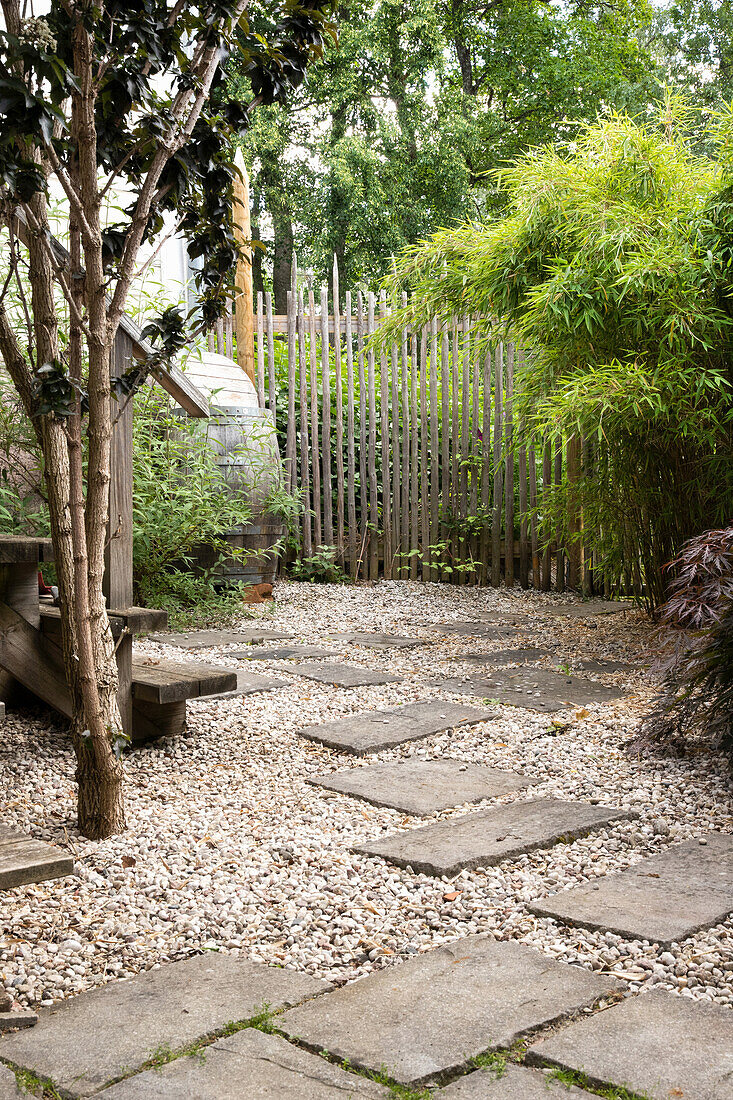 Gartenplatz mit Kies und Betonplatten, Bergbambus am Zaun
