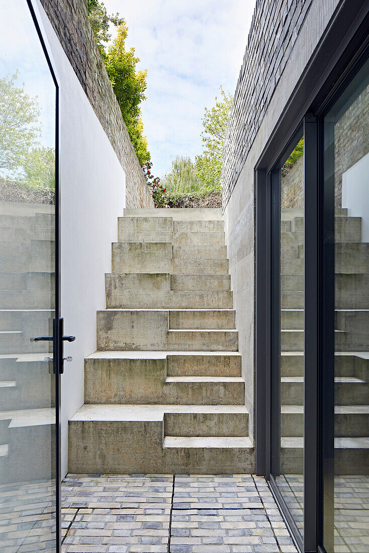 Treppe aus Beton mit zwei verschiedenen Stufenhöhen zum Garten