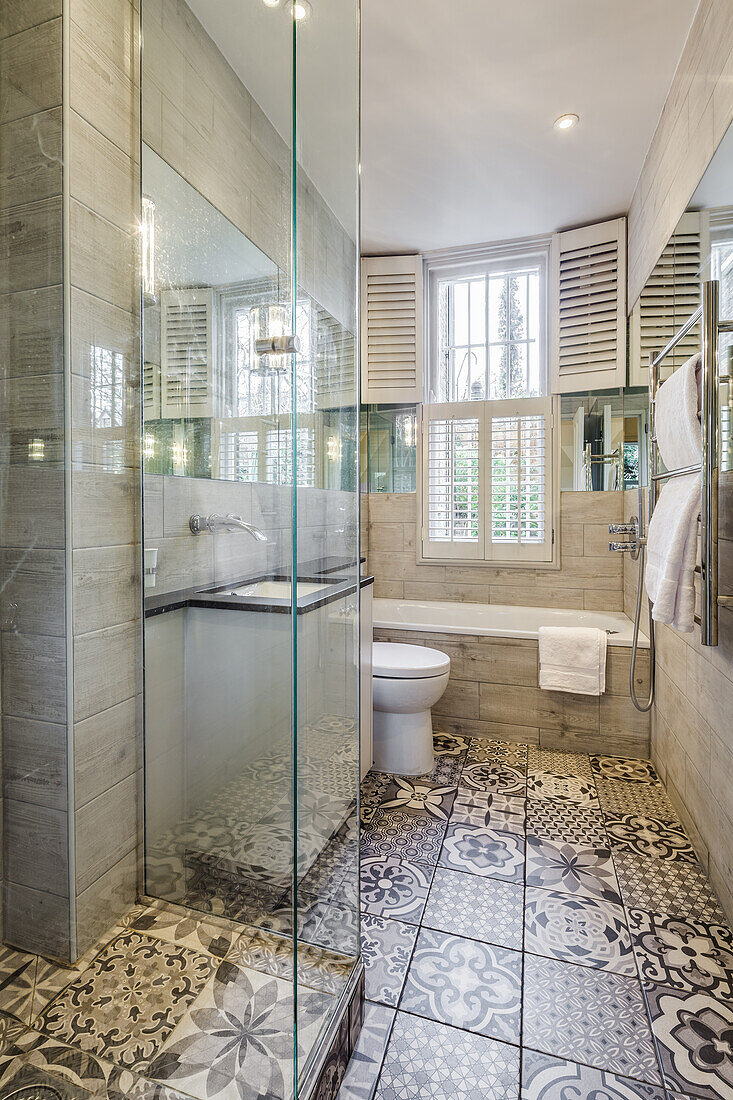 Small bathroom with patterned floor tiles in grey tones