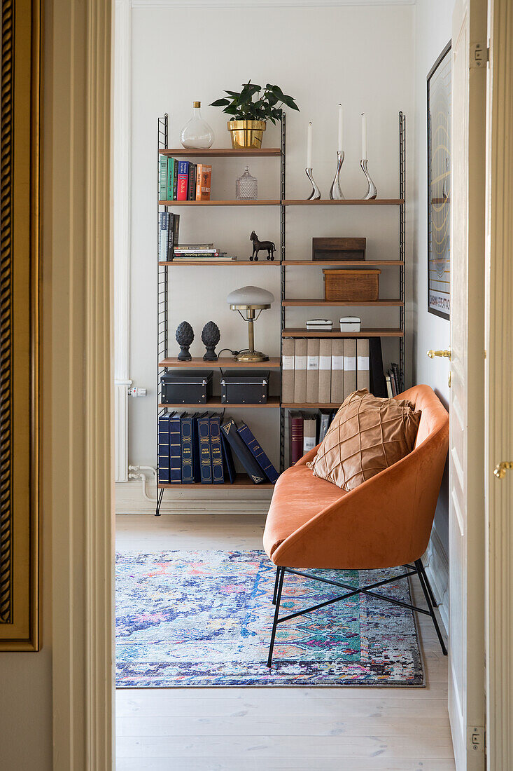 Open shelving unit and brown sofa in the study