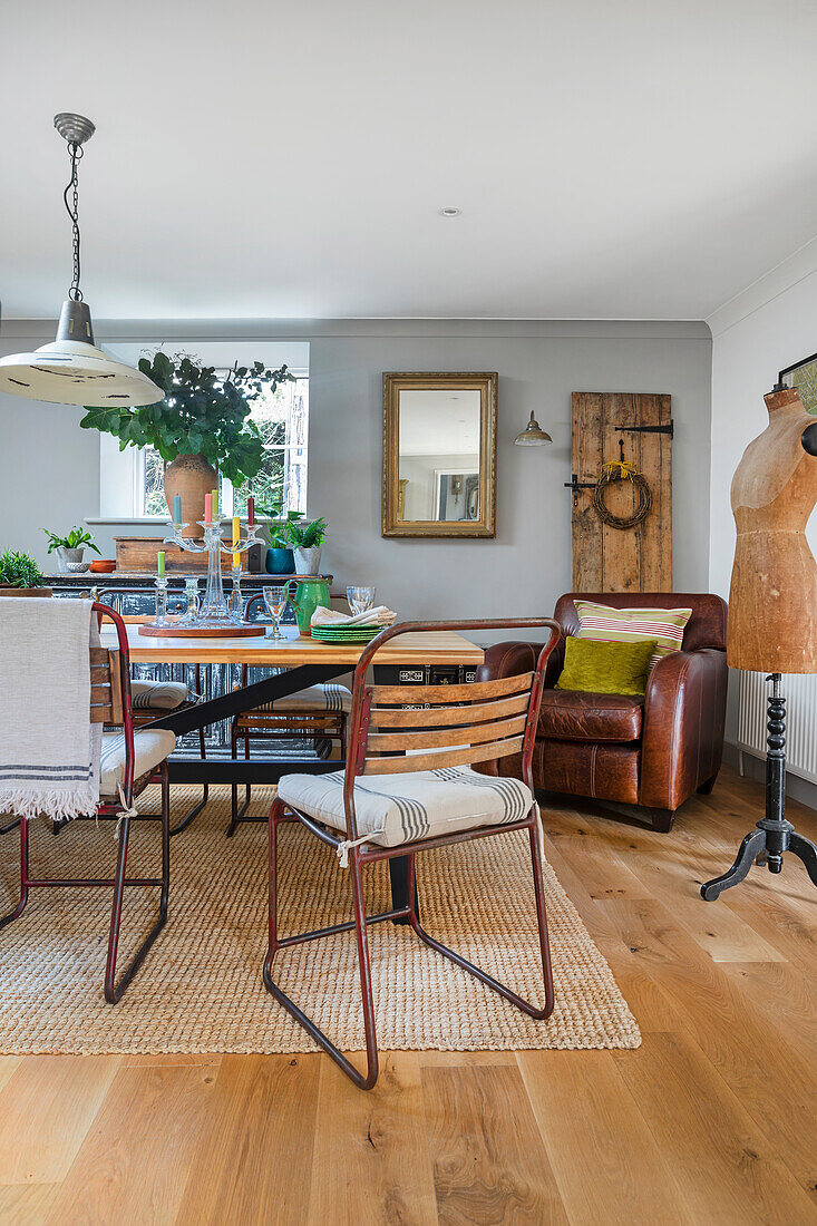 Large table with wooden and metal chairs, dressform and leather armchair