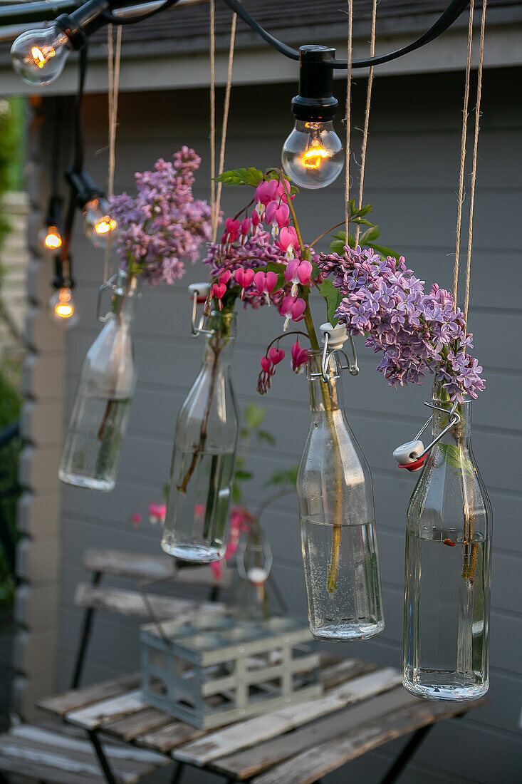 Floating vases made of glass bottles as an outdoor decoration