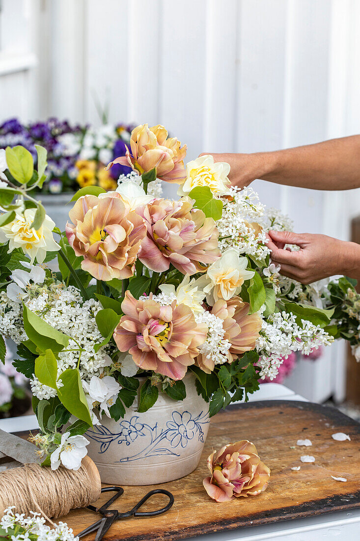 Lush spring bouquet of white lilac, apricot tulip and quince blossoms