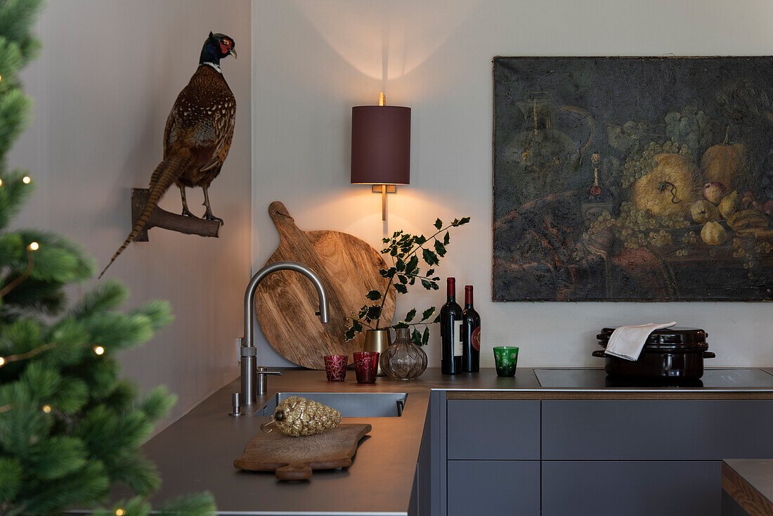 Stuffed pheasant, wall lamp, and picture above kitchen cabinet