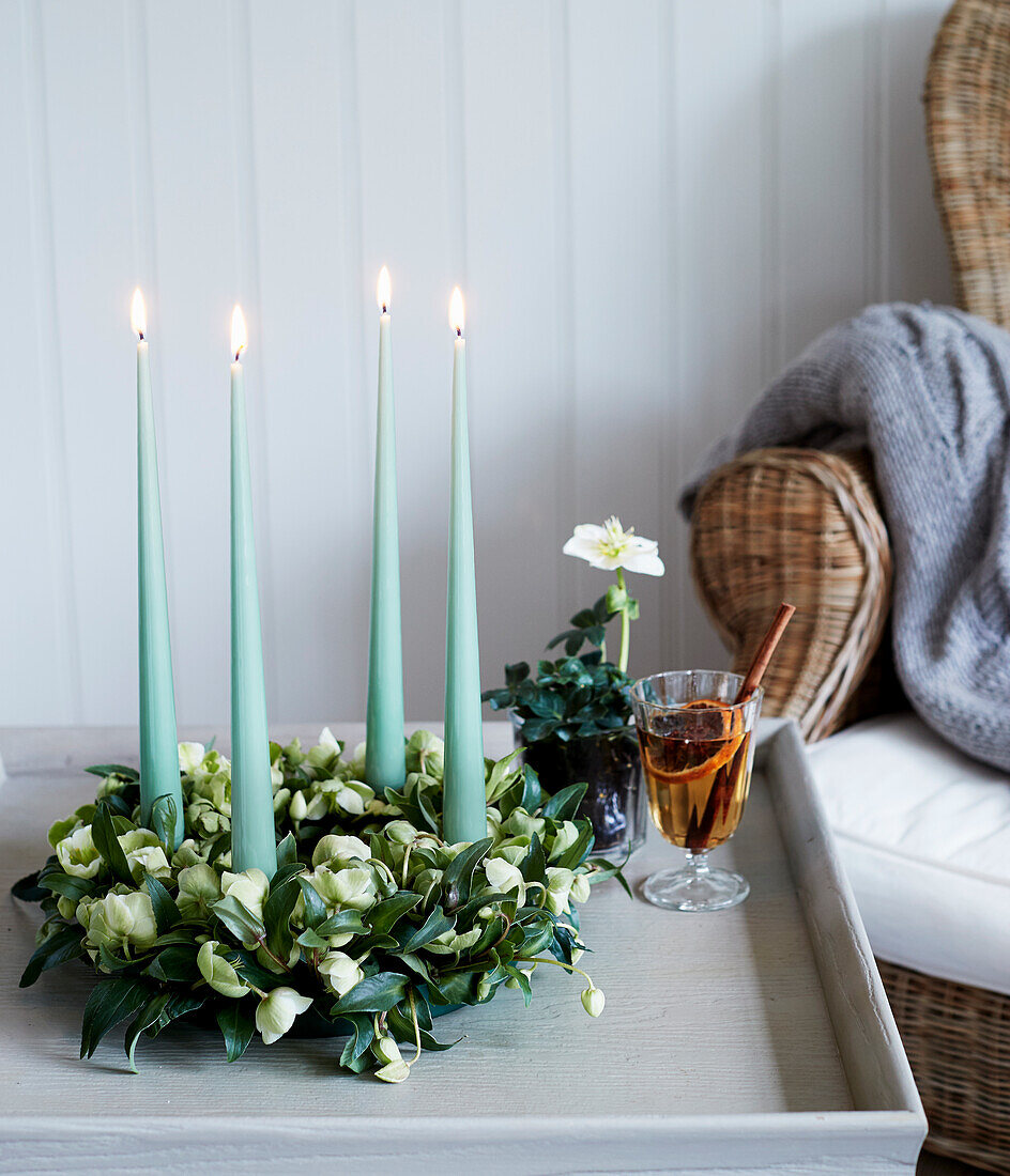 Advent wreath made of Christmas roses with turquoise candles