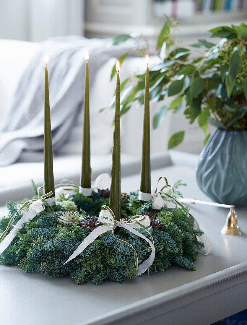 Advent wreath made of conifer branches with green candles