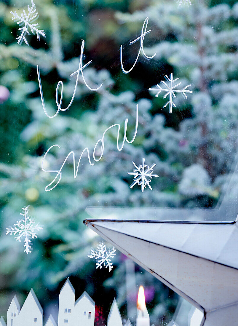 Window decorated with snowflakes and 'Let it snow' lettering
