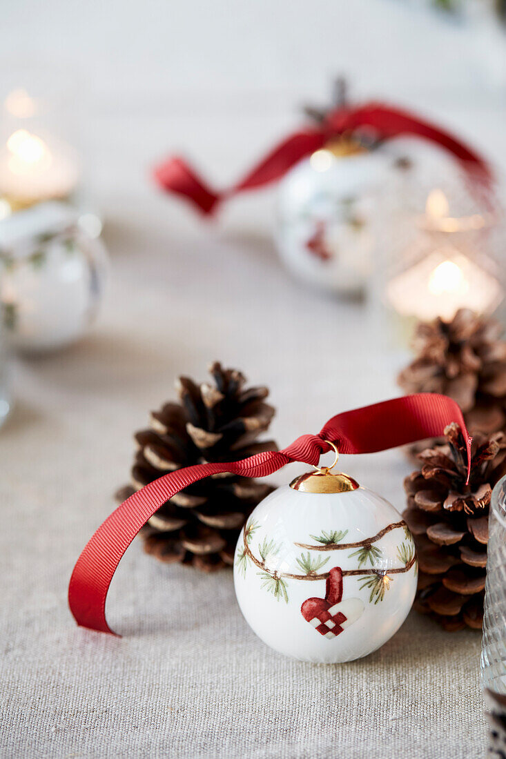 Christmas baubles with red decorative ribbons and pine cones