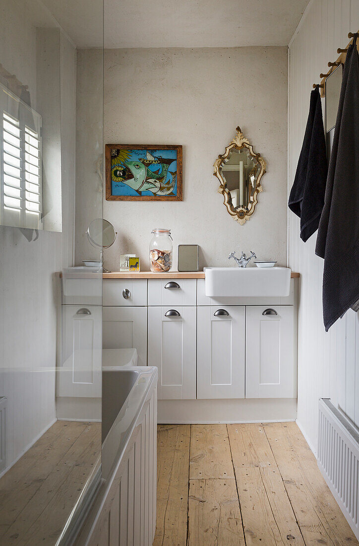 Narrow bathroom with wooden floorboards