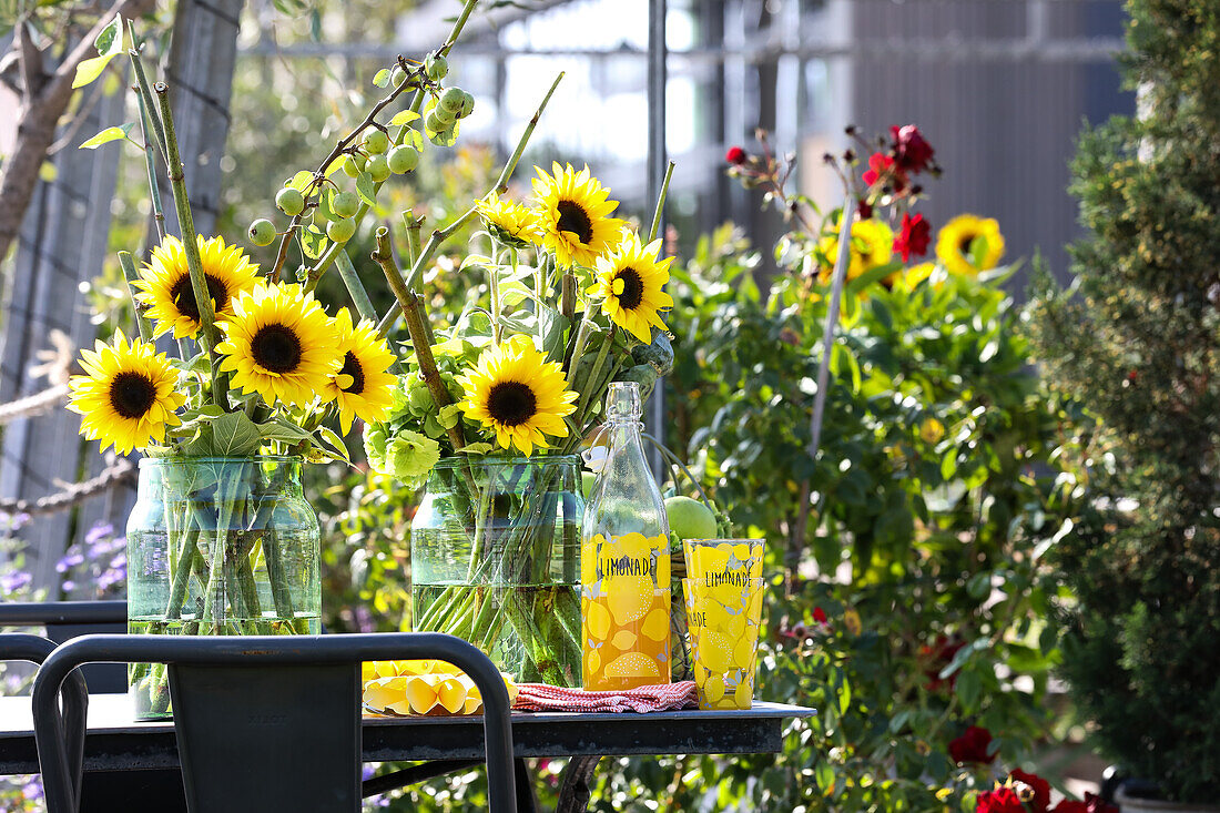 Bouquet of sunflowers and poppy capsules in milk cans