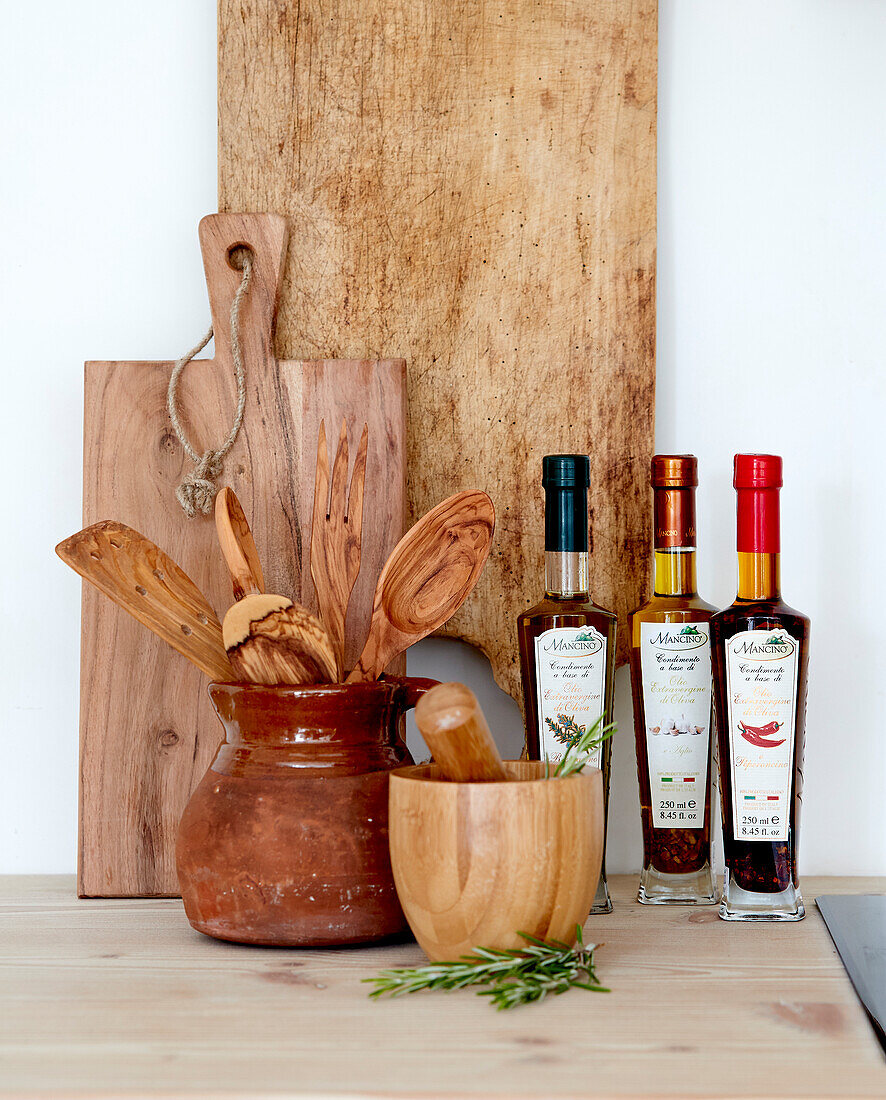 Küchenutensilien aus Holz und Ölflaschen auf Küchenarbeitsplatte