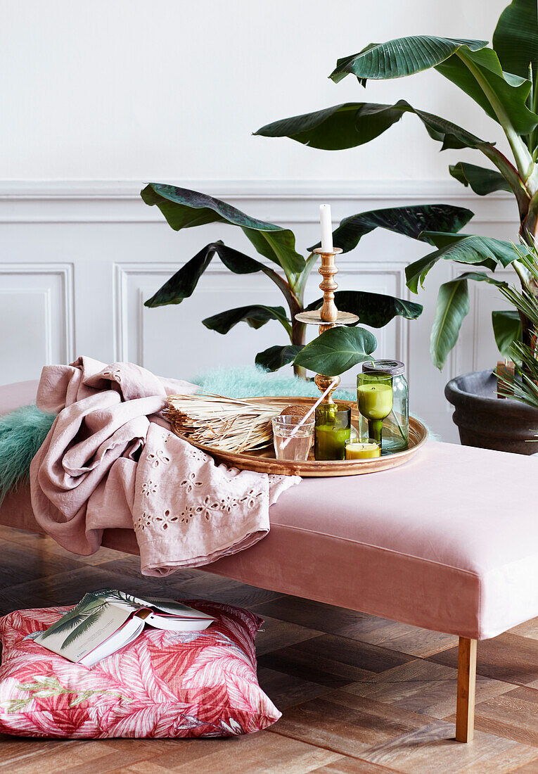 Tray on pink couch surrounded by houseplants