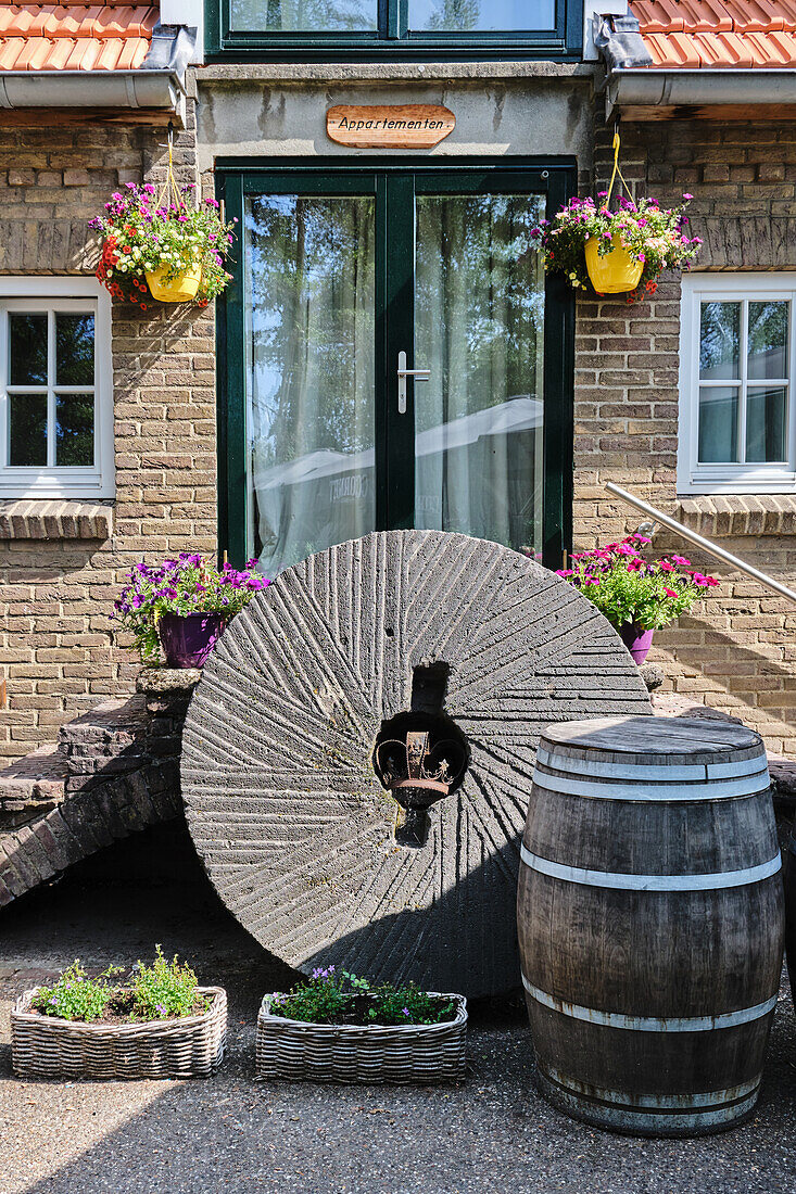 Gasthof-Fassade mit Blumen und altem Weinfass