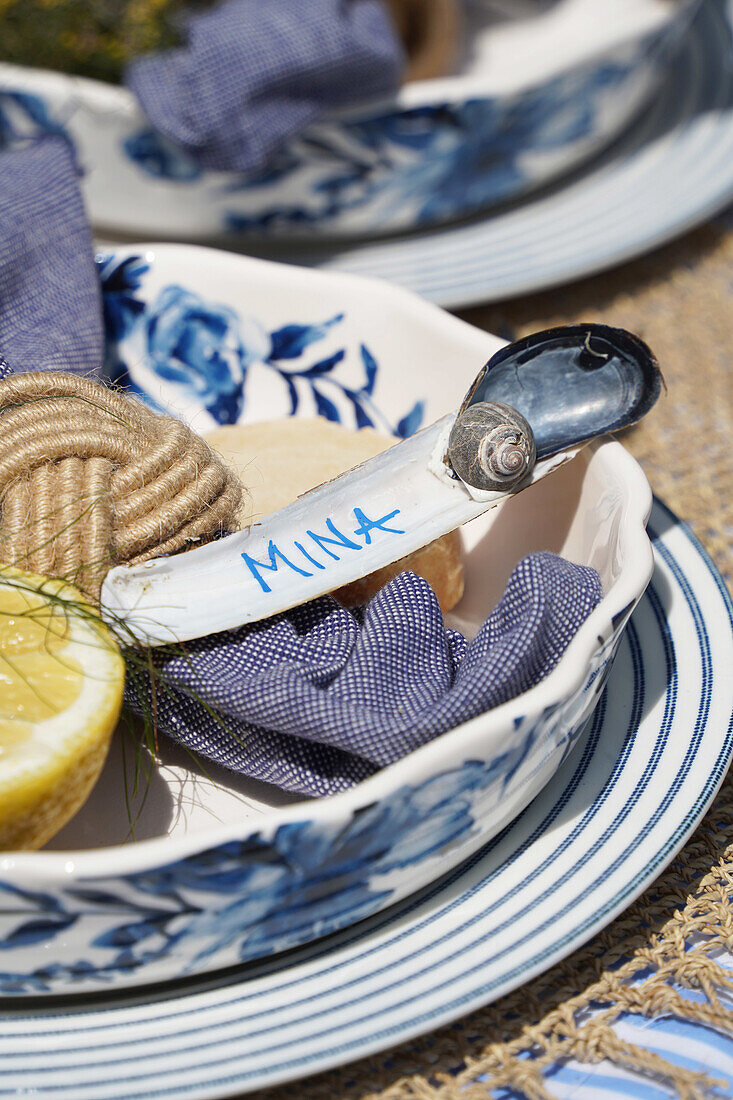 Maritime table decoration with shells, name tag and crockery