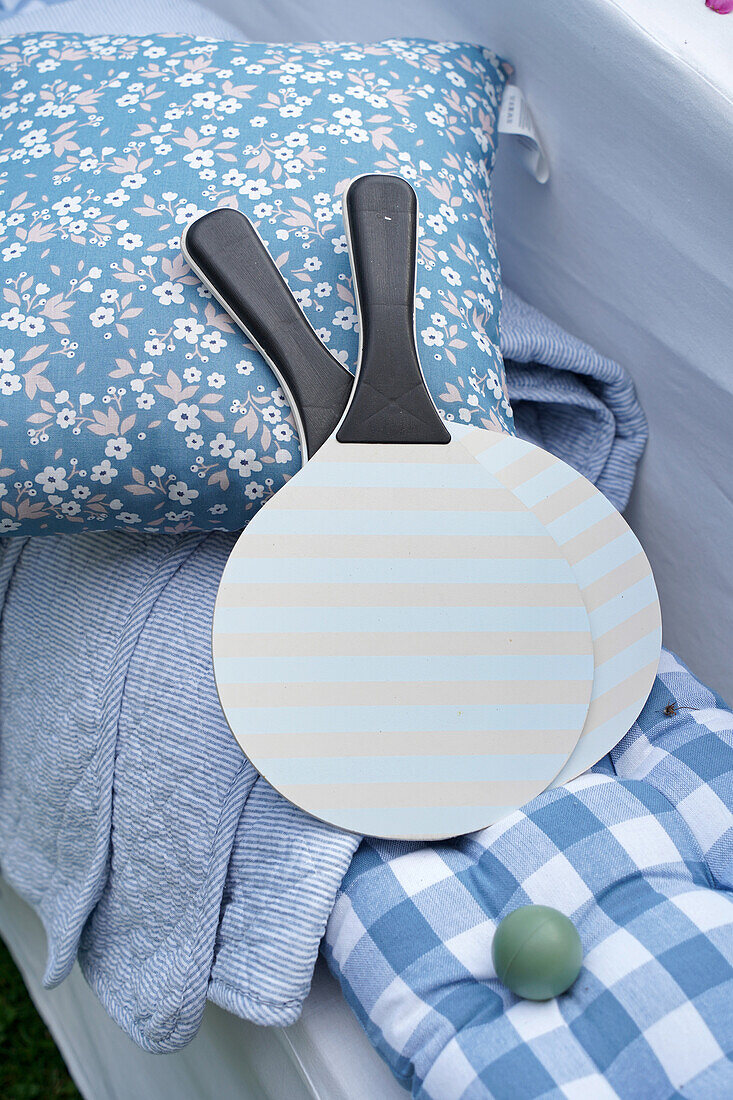 Paddle ball set with striped paddles on patterned cushions