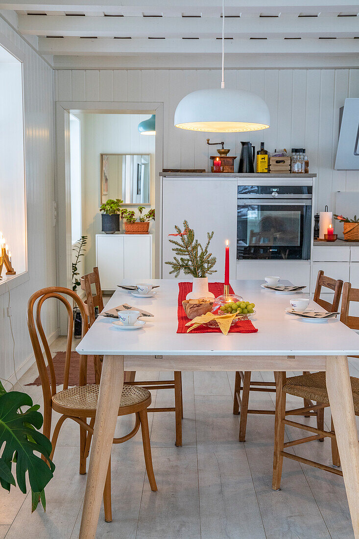 Christmas dining table with wooden chairs in a white kitchen