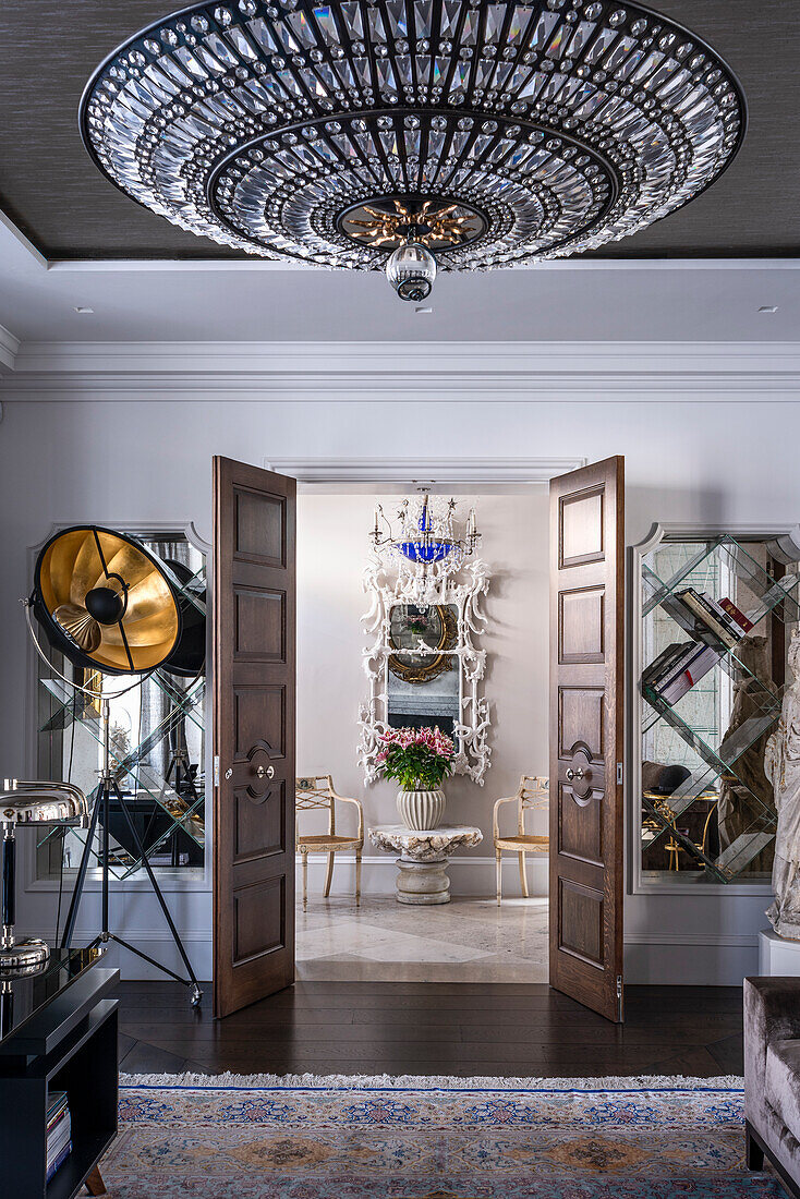 View through open double doors to a chinoiserie mirror and Regency armchair