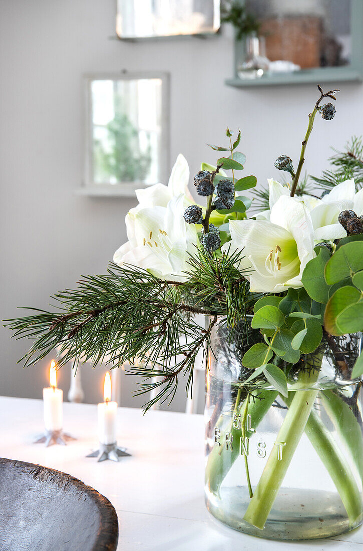 Christmas bouquet with amaryllis and fir branches in glass vase