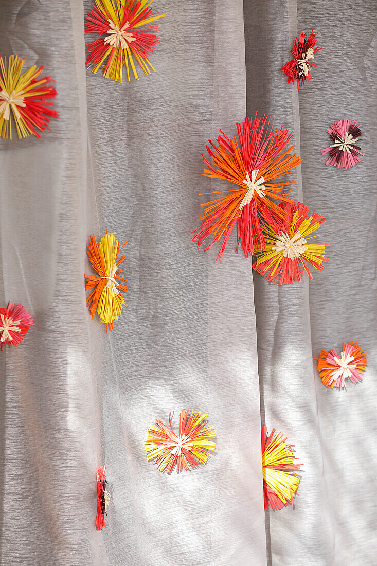 Curtain with colourful raffia stars in bright colours