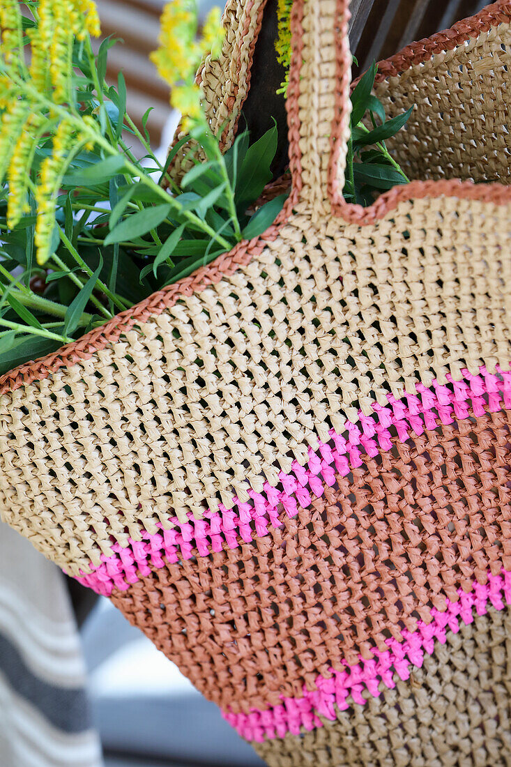 Geflochtene Tasche aus Bast mit pinken Streifen und gelben Blumen