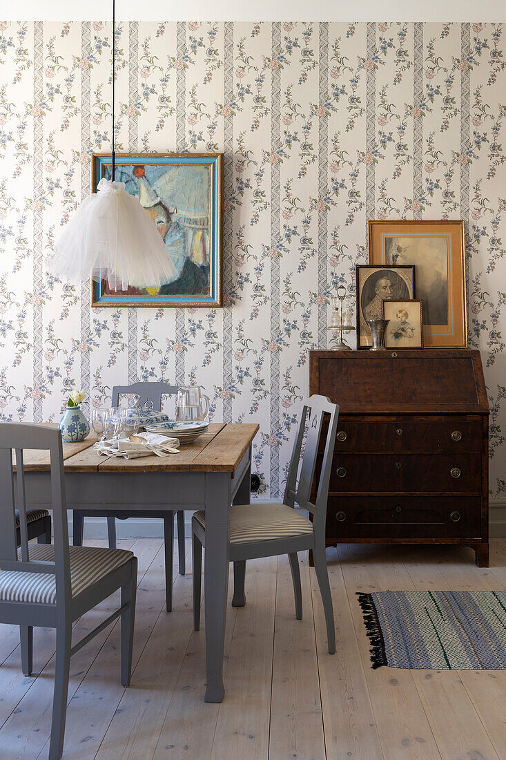 Dining room with blue-grey wooden furniture and floral wallpaper