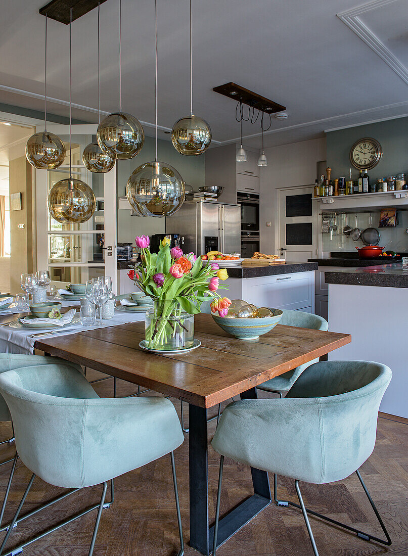 Dining table with upholstered chairs and view of the open kitchen