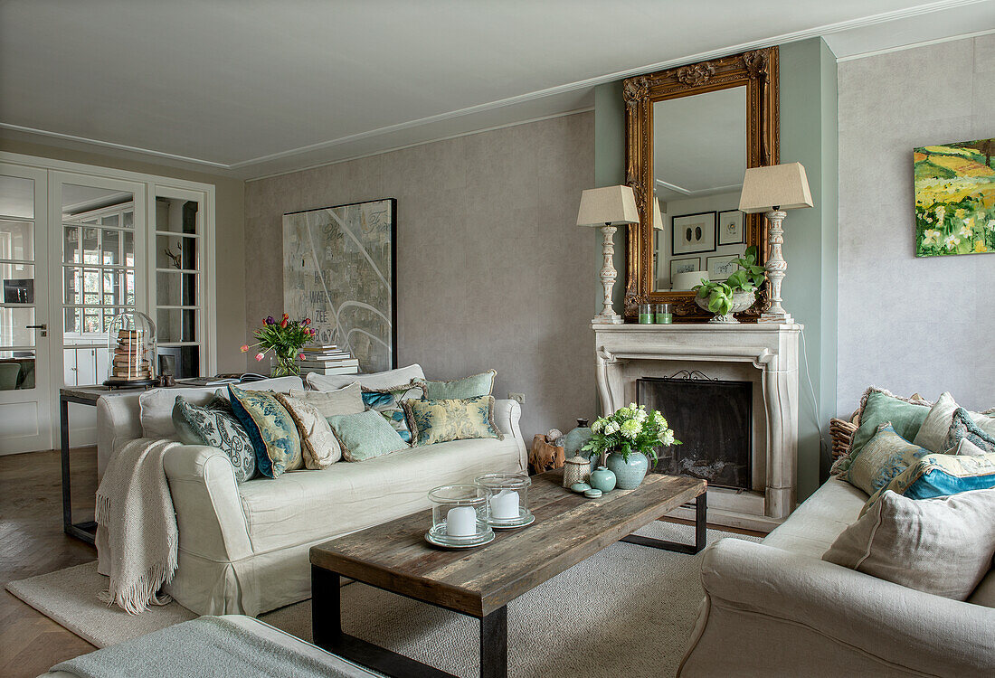 Elegant living room with fireplace, antique mirror and wooden dining table